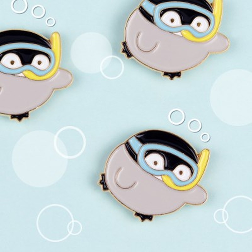 "meta_description": "Discover the Koupenchan badge, a charming gold pin featuring a gentle baby penguin.",