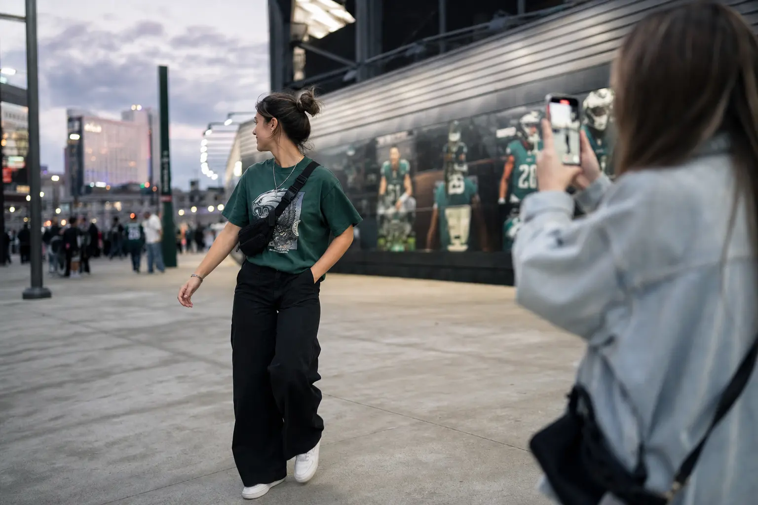 For the photo-ready content section: A young fan on a city sidewalk outside a stadium, mid-stride, captured in a candid