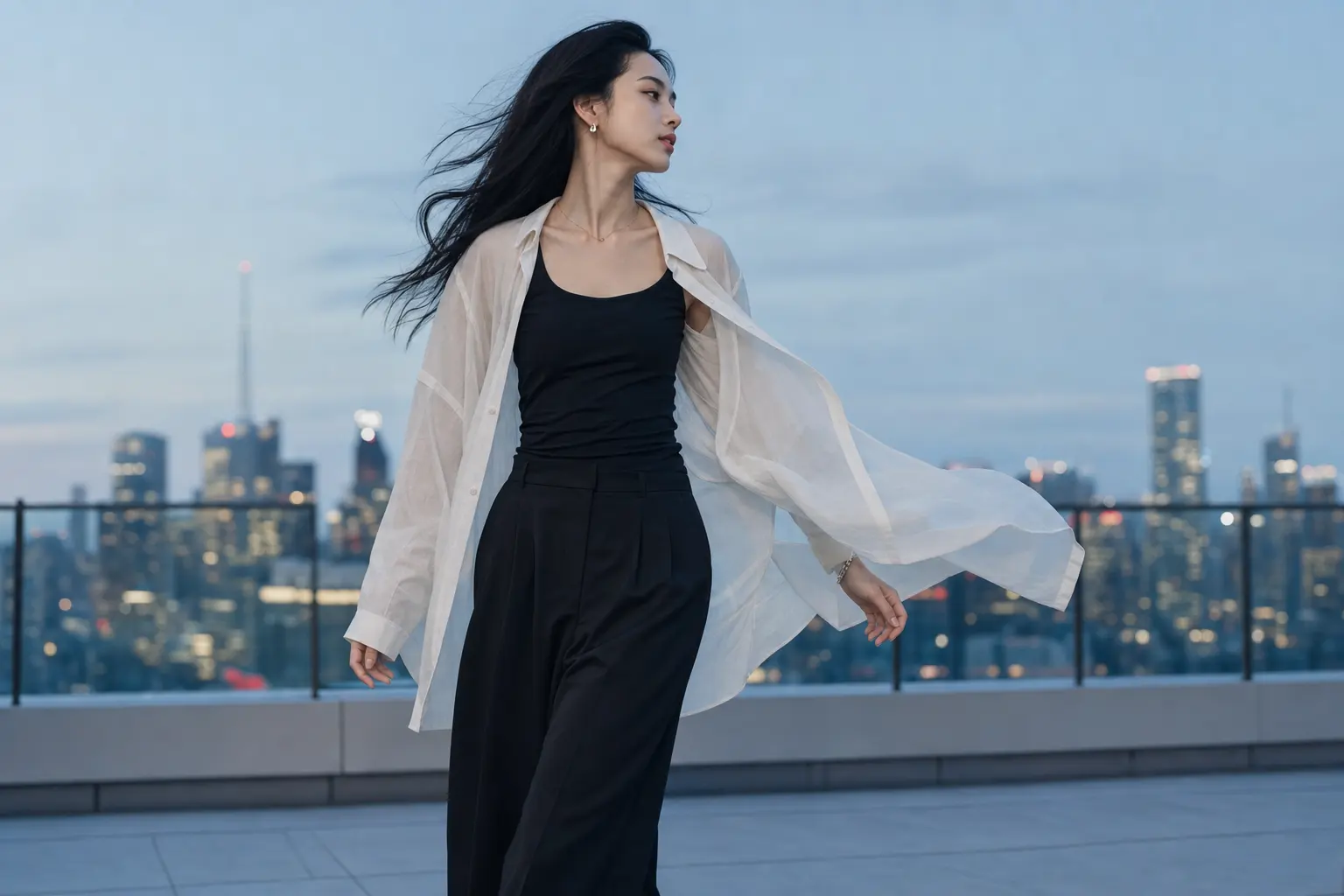 An evening rooftop setting with an air-sign layered look in motion: a person walking with a lightweight overshirt billow
