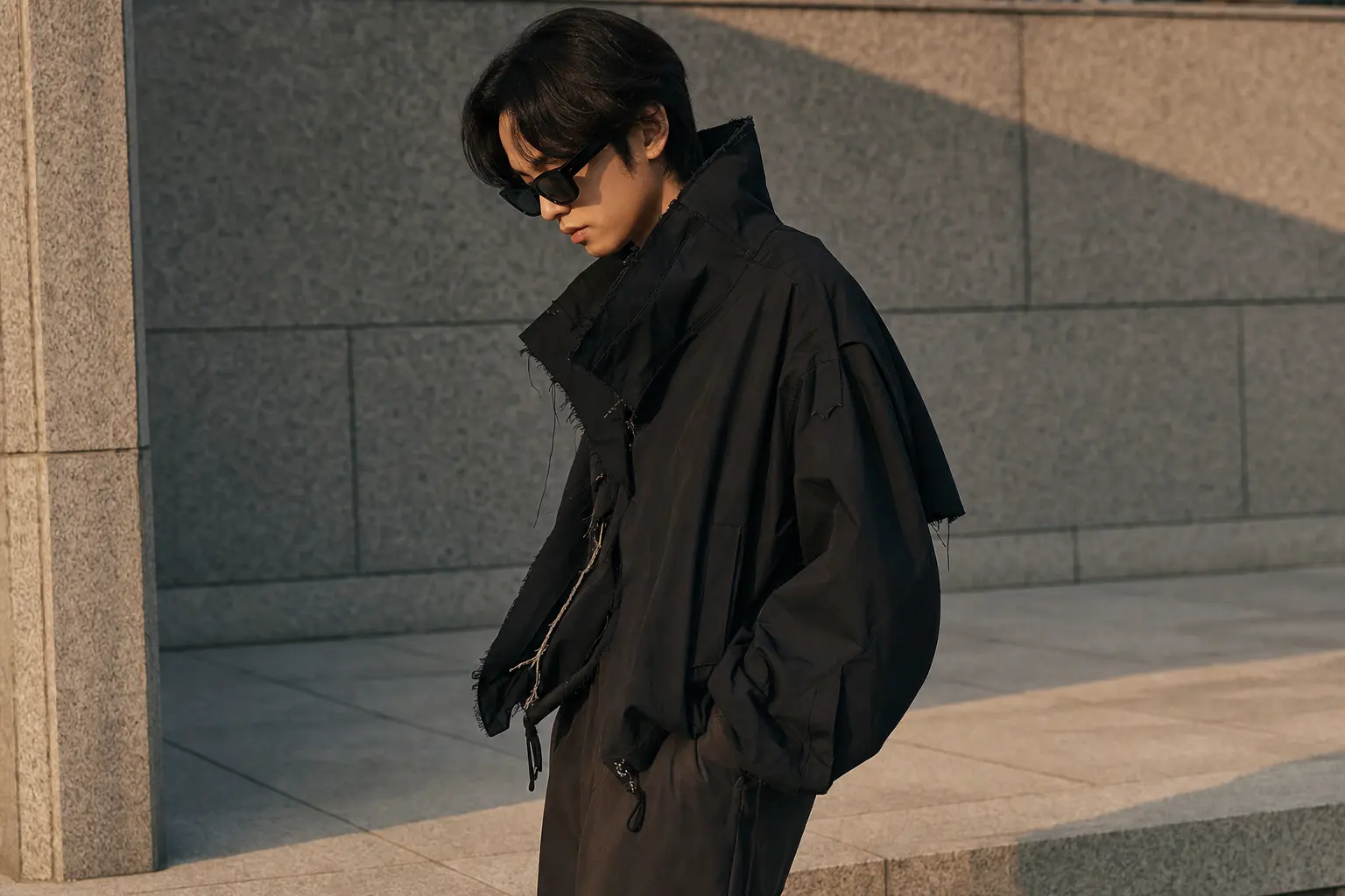 A candid street-style portrait in Seoul: a model wearing an oversized deconstructed jacket, tailored trousers, and bold